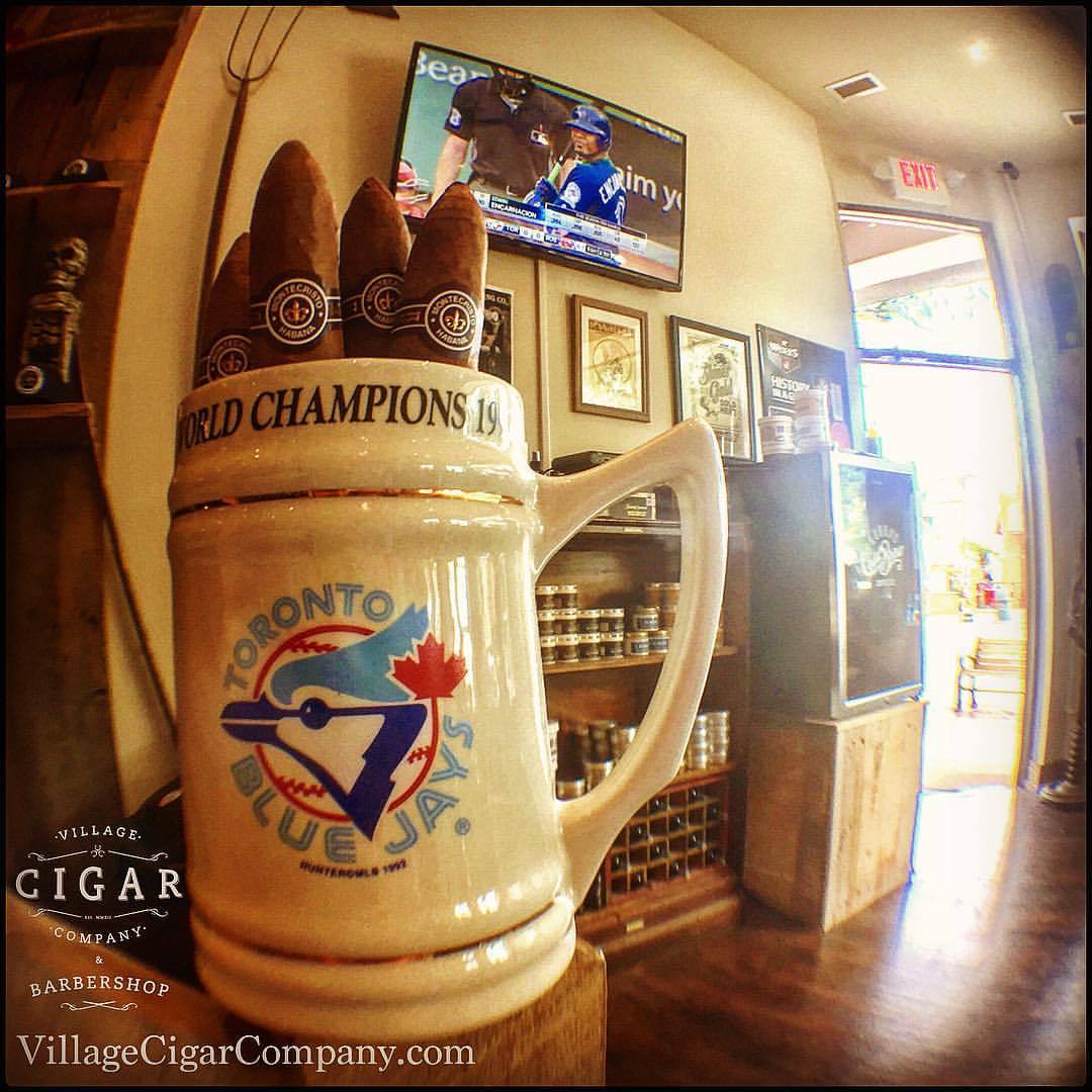 Doors are open. The most important game of the year is on. Clippers are humming and the cigars are ready for celebration. Join us friends and… Let’s Go Blue Jays!!!
Village Cigar Company
& Barbershop
Burlington &...